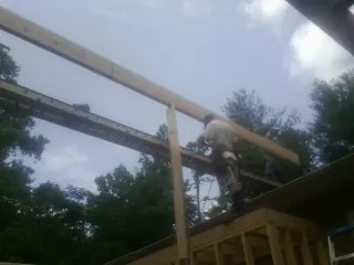 Carpenter setting a ridge beam over a new addition frame — Ice Dam Removal by Roofing Brothers in Pittston