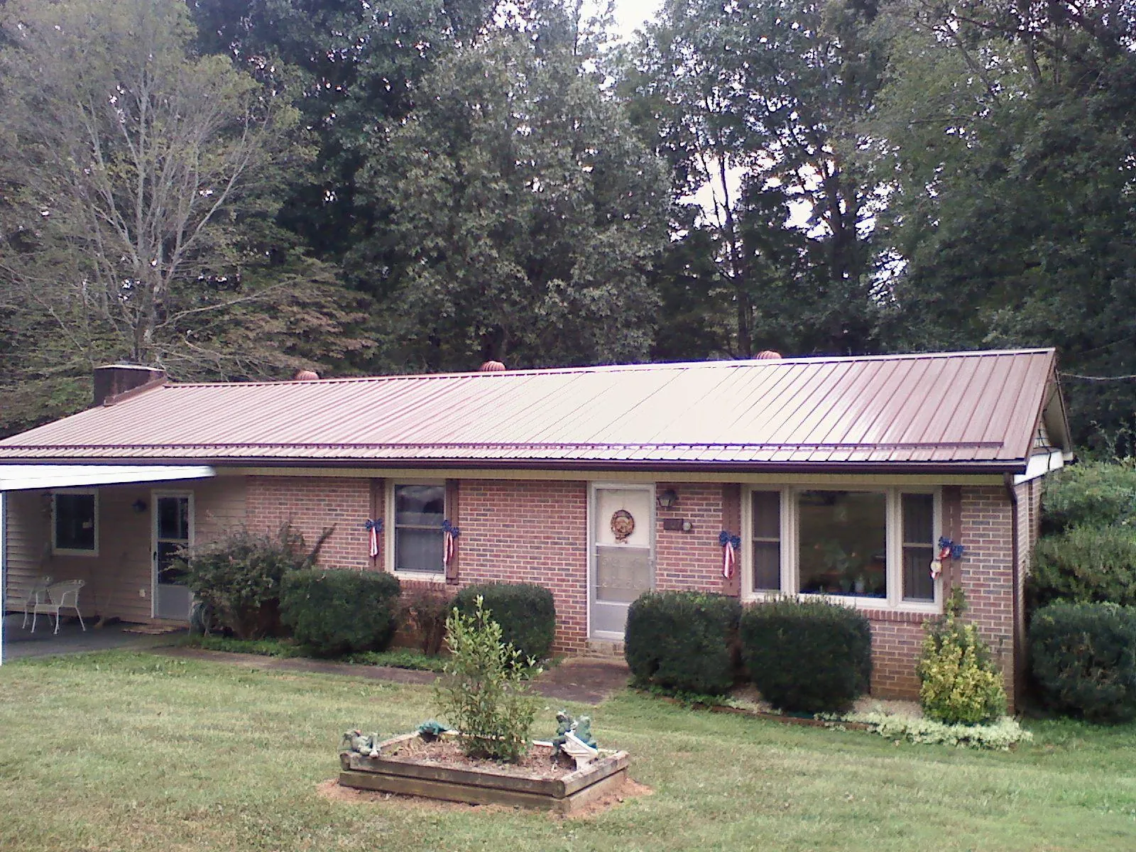 Bronze metal roof on a brick ranch home with a carport in Pittston