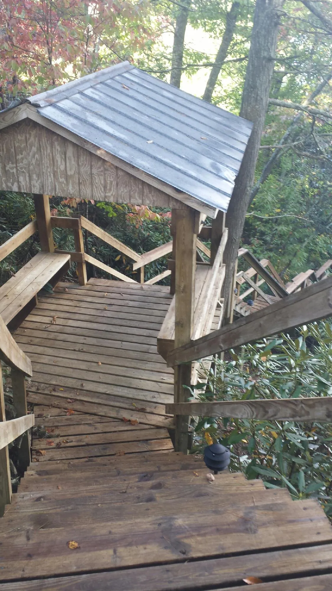 Metal roofed shelter over wooden steps on a wooded walkway — Skylight Repair & Installation work by our crew in Pittston