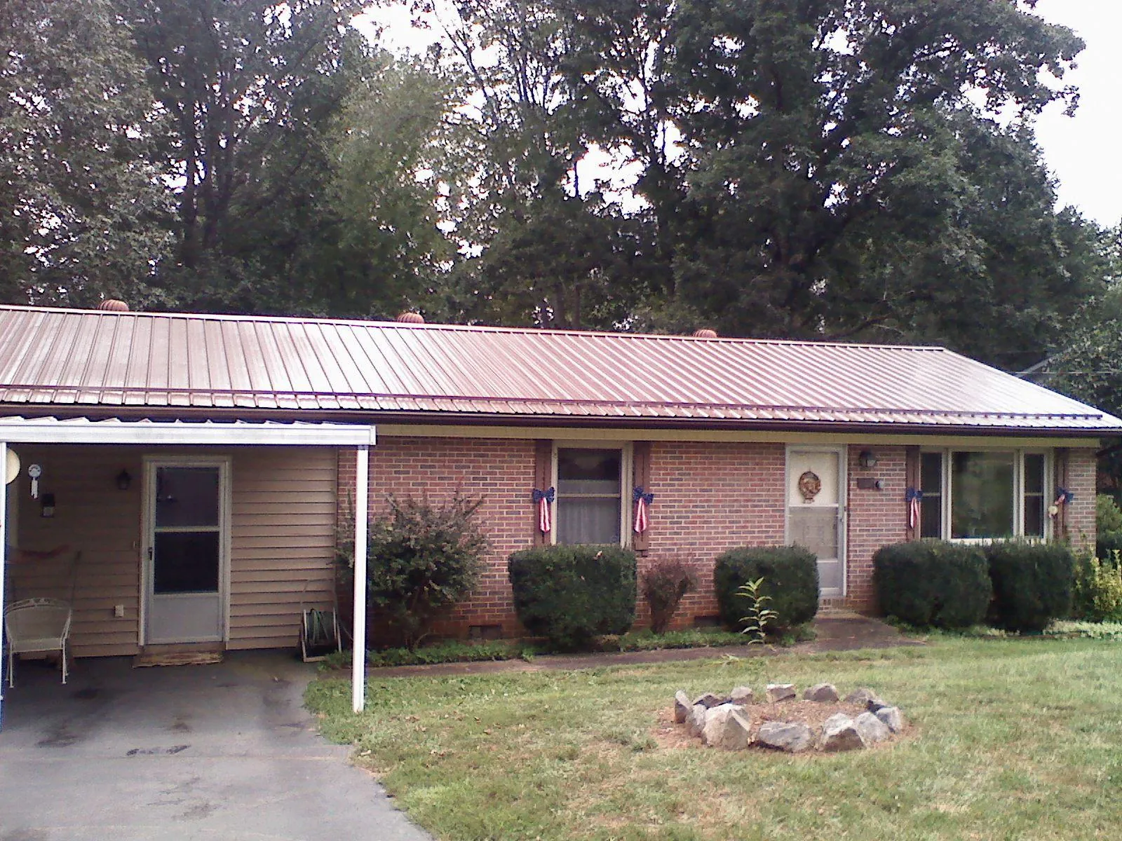 Bronze metal roof and carport on a brick ranch home — Roof Repair work by our crew in Pittston